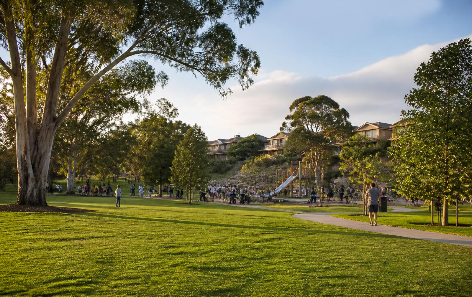 Established Australian suburban parkland with mature gum trees, walking paths, a playground and nearby housing